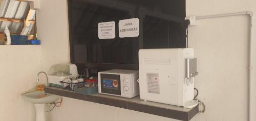 a bathroom shelf with two microwaves and a microwave at RVH Kuala Terengganu in Kuala Terengganu