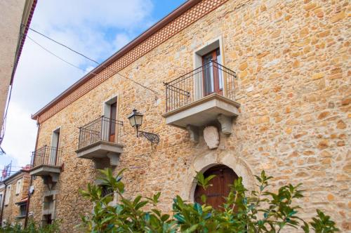 a brick building with two balconies and a door at Palazzo Iaquinta - Rooms, Restaurant & Wellness in Cicerale