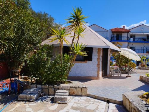 a house with a palm tree and a patio at Spasmata Marios bungalows in Minia