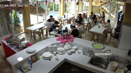 a group of people sitting at tables in a restaurant at Crystal Shores Beach Resort powered by Cocotel in Malawin