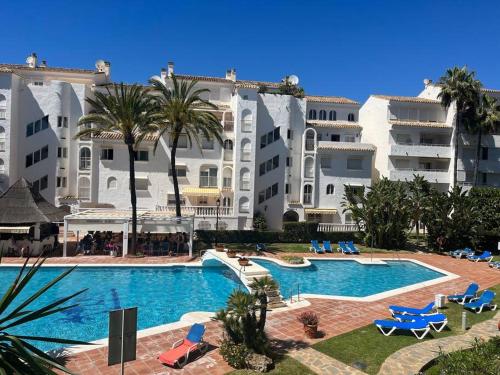 un gran hotel con piscina y palmeras en Marbella Playa Real with sea view, en Marbella