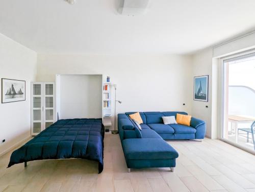 un soggiorno con divano blu e letto di La Vela a Finale Ligure