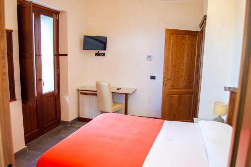 a bedroom with a bed and a desk and a table at Palazzo Iaquinta - Rooms, Restaurant & Wellness in Cicerale