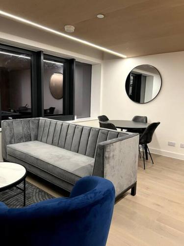 a living room with a couch and tables and a mirror at 2 Bedroom Maisonette in Salford in Manchester