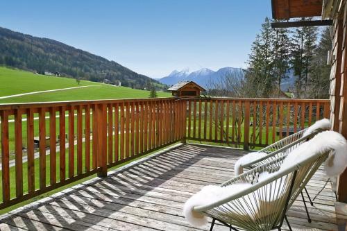 a deck with a bench and a view of a mountain at Traum Chalet mit Privatwald & Almhütte in Irdning