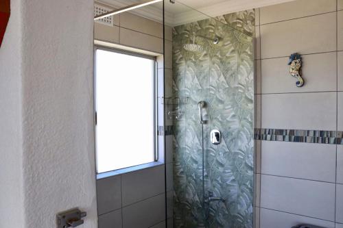 a shower with a glass door in a bathroom at laguna la Crete 98 in Uvongo Beach