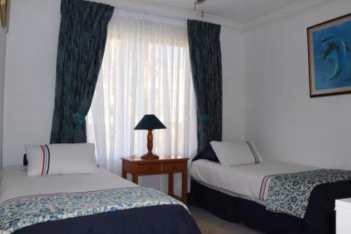 a hotel room with two beds and a window at laguna la Crete 98 in Uvongo Beach