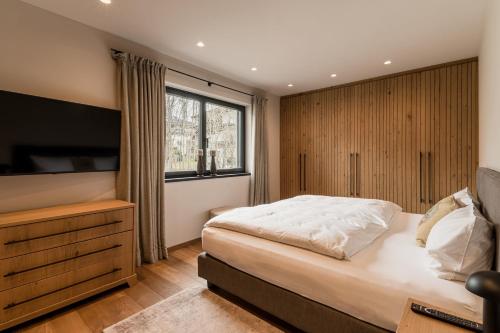 a bedroom with a large bed and a television at Mountain View Chalet Going in Going
