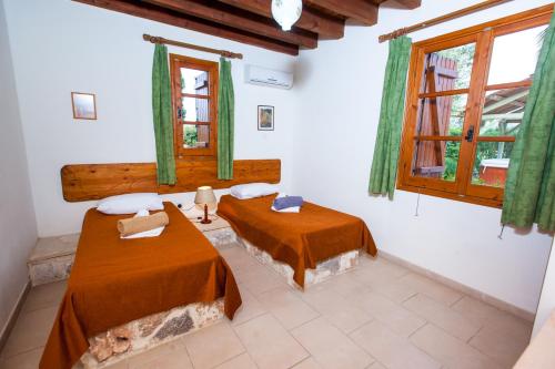 2 letti in una camera con tende verdi di Villa Olive Grove 3 a Paphos