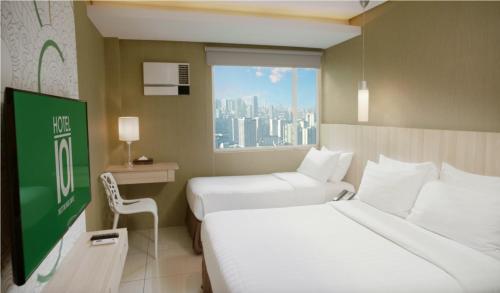 マニラにあるHotel101 - Fortのベッド2台と窓が備わるホテルルームです。