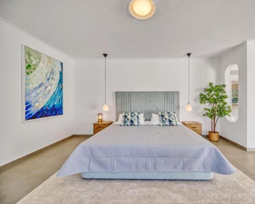 a bedroom with a bed and a painting on the wall at Villa Beleza in Portimão