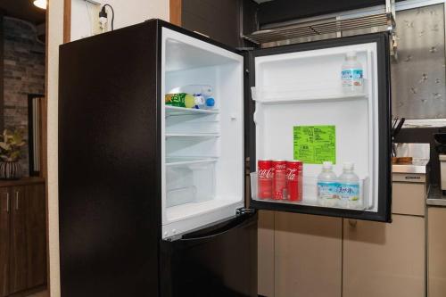 a refrigerator with its door open in a kitchen at Osaka private house 3 bed rooms for max 10ppl in Osaka