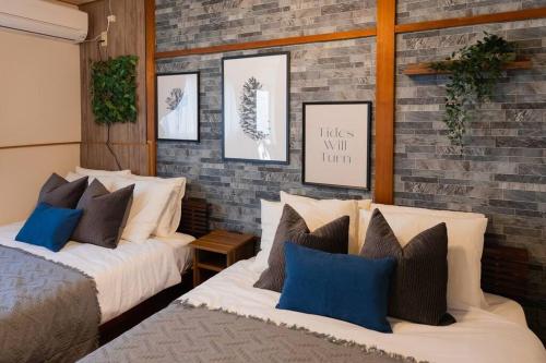 a bedroom with two beds and a brick wall at Osaka private house 3 bed rooms for max 10ppl in Osaka