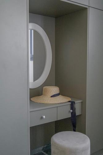 a hat sitting on a counter with a mirror at Anthemion Paros - Villas & Suites in Agia Irini Paros
