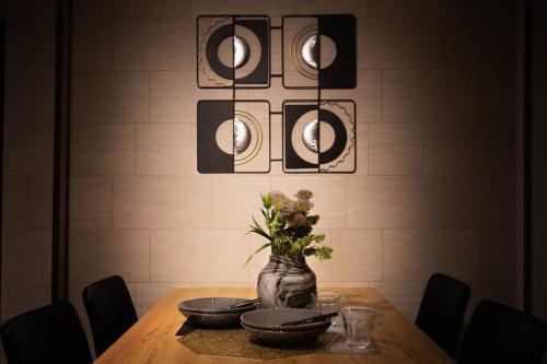a table with two bowls and a vase with flowers at Osaka private house 3 bed rooms for max 10ppl in Osaka