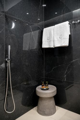a bathroom with a shower and a toilet and towels at Malmo Historic Hotel in Chania Town