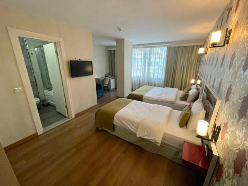 a hotel room with two beds and a television at Era Palace Hotel in Istanbul