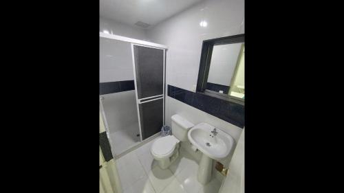 ein Badezimmer mit Toilette, Waschbecken und Spiegel in der Unterkunft Cozy room Bm-10 near the sea with air conditioning and WIFI in Cartagena de Indias