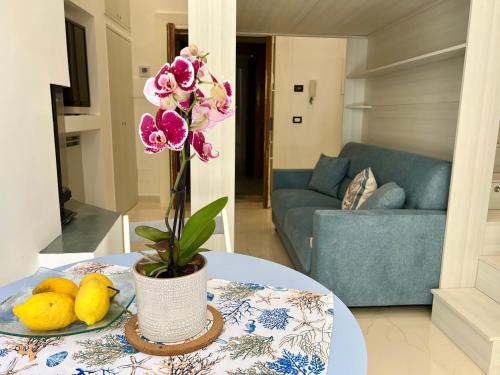 a table with a vase of flowers and some lemons at LEI LUXURY APARTMENT in Maiori