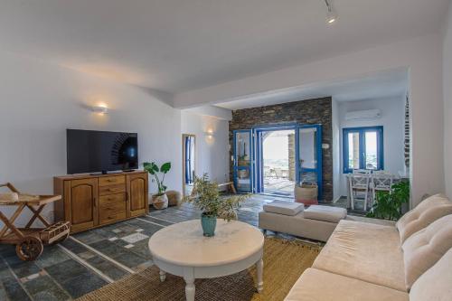 a living room with a couch and a tv at Anthemion Paros - Villas & Suites in Agia Irini Paros