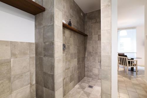 a bathroom with a walk in shower next to a table at Nenè-Il Vicolo Apartments and Rooms in Bellagio