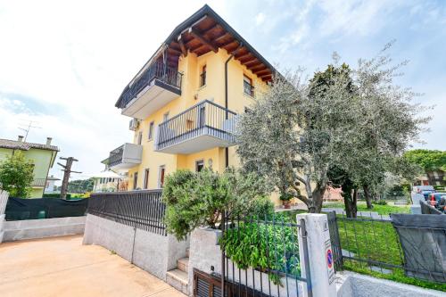 una casa gialla con una recinzione di fronte di Pearl House - Sirmione Holiday - Jacuzzi Privata a Sirmione