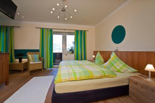 a bedroom with a large bed with green curtains at Landhaus Almdorf in Sankt Johann in Tirol
