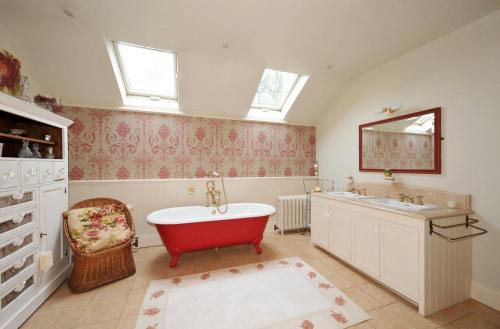 a bathroom with a red tub and a sink at Luxury Country House Glendalough Wicklow in Laragh