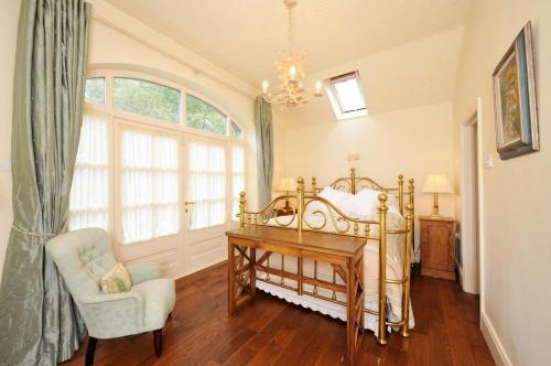 a bedroom with a bed and a chair and a window at Luxury Country House Glendalough Wicklow in Laragh
