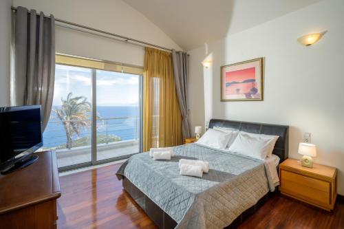 Schlafzimmer mit einem Bett und Meerblick in der Unterkunft Aegean Blue Dream Villa in Ligaria