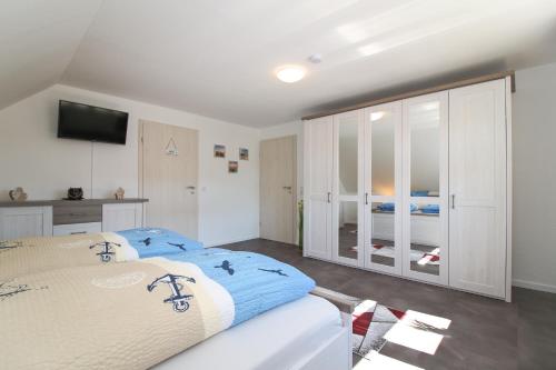a bedroom with a large bed and a television at Ferienwohnungen Gatena in Norddeich
