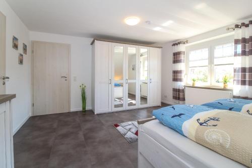 a bedroom with a bed and a large window at Ferienwohnungen Gatena in Norddeich