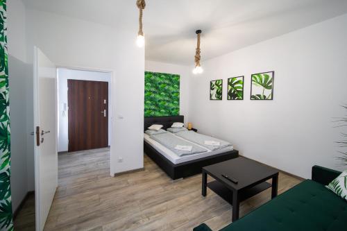 - une chambre avec un lit et une table dans l'établissement Jungle Vision Apartment - Rynek, à Carolinensiel