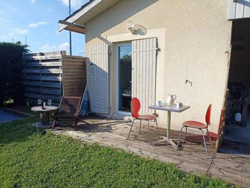 eine Terrasse mit 2 Stühlen und einem Tisch mit 2 Tischen in der Unterkunft Aux portes de Bordeaux, chambre indépendante in Cénac
