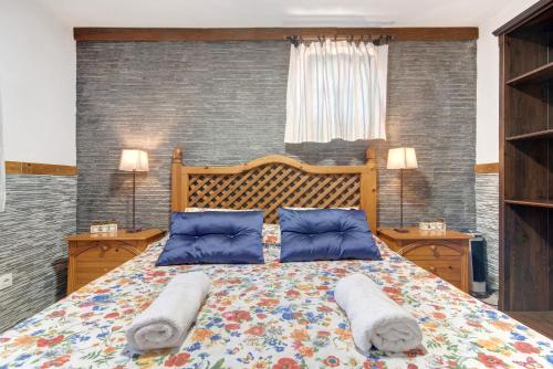een slaapkamer met een groot bed met 2 kussens bij Villa La Quinta de Vals in Valsequillo