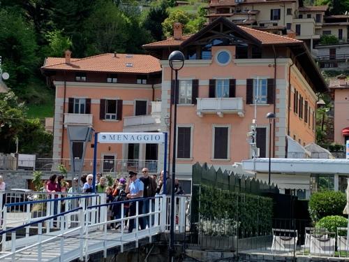 a group of people standing on a bridge in front of a building at Zippity Doo Dah - Menaggio Home - Como Lake in Menaggio