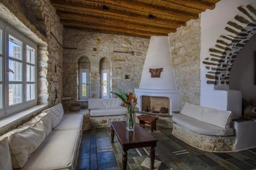 a living room with a couch and a fireplace at Anthemion Paros - Villas & Suites in Agia Irini Paros