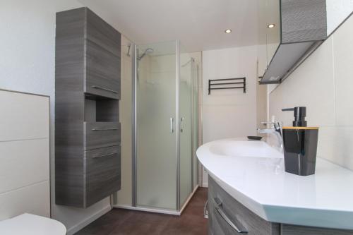 a bathroom with a sink and a shower at Ferienwohnungen Gatena in Norddeich
