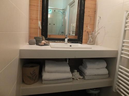 a bathroom with a sink and a pile of towels at Wooden house by the sea in Hourtin