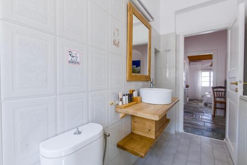 a white bathroom with a toilet and a sink at Anthemion Paros - Villas & Suites in Agia Irini Paros
