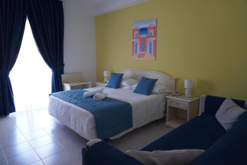 a hotel room with a bed and two chairs at Hotel Parco Delle Agavi in Ischia