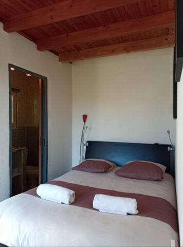 ein Schlafzimmer mit einem großen weißen Bett mit zwei Kissen in der Unterkunft Aux portes de Bordeaux, chambre indépendante in Cénac