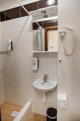 a white bathroom with a sink and a phone at Na Horyzonti in Truskavets