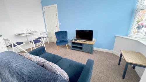 a living room with a blue couch and a table at Friars House, Stafford by BELL Apartments in Stafford