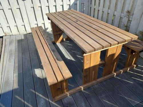 a wooden picnic table and bench on a deck at Amazing Beach House, Sleeps 8, Pet Friendly in Trearddur