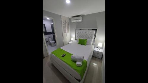 ein Schlafzimmer mit einem grün-weißen Bett in einem Zimmer in der Unterkunft Bm-13 room near the sea with air conditioning and WIFI in Cartagena de Indias