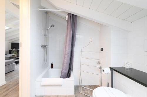 a white bathroom with a shower and a toilet at Nenè - La Scalinata apartments in Bellagio