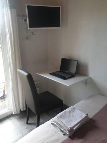 einen Laptop auf einem Schreibtisch in einem Zimmer in der Unterkunft Aux portes de Bordeaux, chambre indépendante in Cénac