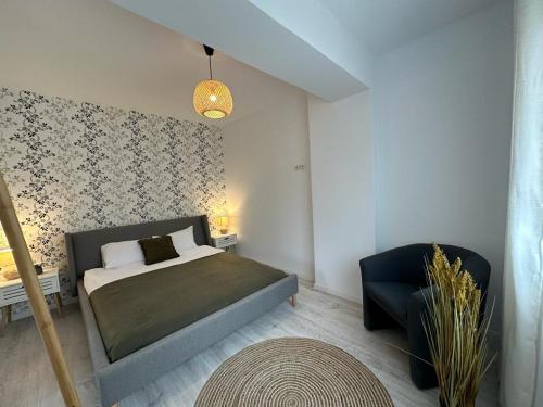 sypialnia z łóżkiem i krzesłem w obiekcie City Center Accommodation 111 w mieście Reşiţa