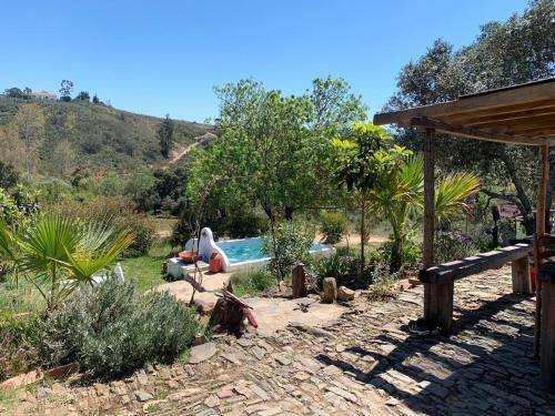 a garden with a swimming pool in the middle of it at The Stream House - Montes da Ronha in Zambujeira do Mar